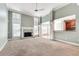 Inviting living room featuring a fireplace, large windows, a view to the kitchen, and neutral carpeting at 2477 Misty Rose Ln, Loganville, GA 30052