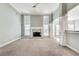 Spacious living room with a cozy fireplace, large windows, neutral carpet, and elegant architectural details at 2477 Misty Rose Ln, Loganville, GA 30052