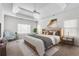 Serene main bedroom showcasing a tray ceiling, ceiling fan, a neutral palette, and large windows at 2477 Misty Rose Ln, Loganville, GA 30052