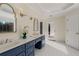 Bathroom with a double sink vanity with granite countertops and decorative gold-trimmed mirrors at 2885 Towne Village Dr, Duluth, GA 30097