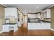 Open-concept kitchen with white cabinetry, granite countertops, stainless appliances, and hardwood floors at 2885 Towne Village Dr, Duluth, GA 30097