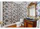 Charming powder room featuring unique floral wallpaper, wood vanity, gold mirror, and hardwood floors at 2885 Towne Village Dr, Duluth, GA 30097