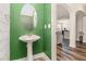 Bright half-bathroom with a stylish green accent wall and pedestal sink at 668 Sprayberry Dr, Stockbridge, GA 30281