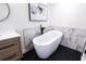 Bathroom showcasing a freestanding tub with black fixtures, hexagon tile floor, and modern vanity at 1416 Mcpherson Se Ave, Atlanta, GA 30316