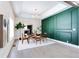 Elegant dining area with a decorative green accent wall, modern light fixture, and hardwood flooring at 1416 Mcpherson Se Ave, Atlanta, GA 30316