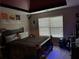 Comfortable bedroom featuring a bed with a dark frame, light-colored walls, and a large window with blinds at 150 Bellemeade Ct, Fayetteville, GA 30215