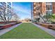 Exterior grounds featuring a lush green lawn, benches, and a condominium building at 1820 Peachtree Nw St # 1207, Atlanta, GA 30309