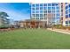 Exterior grounds featuring a lush green lawn and a large condominium building in the background at 1820 Peachtree Nw St # 1207, Atlanta, GA 30309