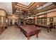 Relaxing billiards room with stone fireplace and multiple tables under pendant lights at 223 Misty View Dr, Canton, GA 30114