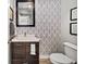 Bathroom featuring a dark vanity, decorative wall paper, modern fixtures, and a framed mirror above the sink at 307 Cherokee Se Ave # 9, Atlanta, GA 30312