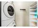 Functional laundry area featuring a washer and dryer with side shelving and a hanging rack for storage at 307 Cherokee Se Ave # 9, Atlanta, GA 30312