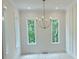 Bright dining room with white walls, wood floors, chandelier, and two large windows showcasing lush greenery at 003 White St # 3, Marietta, GA 30060