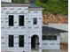 Unfinished two story exterior showing Typar wrap, black window frames and arched door frame detail at 10849 Serenbe Ln, Chattahoochee Hills, GA 30268