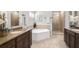 Main bathroom with dual sinks, soaking tub, and separate shower, offering a spa-like experience at 5970 Somersby Cir, Alpharetta, GA 30005