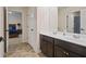 Bathroom with double sinks, dark cabinetry, tile floors and a doorway to the bedroom at 1326 Harlequin Way, Stockbridge, GA 30281