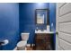 Stylish powder room with dark vanity and fixtures, complete with blue painted walls at 1326 Harlequin Way, Stockbridge, GA 30281