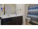 Bright bathroom with double sinks, dark cabinetry, tile floors and a decorative shower curtain at 1326 Harlequin Way, Stockbridge, GA 30281