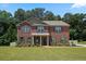 Charming two-story brick home with a well-maintained lawn and traditional design elements at 1326 Harlequin Way, Stockbridge, GA 30281