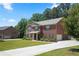 Classic brick home with an attached garage and long driveway nestled on a well-manicured lot at 1326 Harlequin Way, Stockbridge, GA 30281