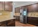 Modern kitchen featuring stainless steel appliances, granite countertops, and dark wood cabinets at 1326 Harlequin Way, Stockbridge, GA 30281