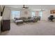 Spacious living room with a large sectional sofa, ceiling fan, and plenty of natural light at 1326 Harlequin Way, Stockbridge, GA 30281