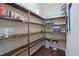 Walk-in pantry with beautiful wood shelving provides ample storage space for all your essentials at 1326 Harlequin Way, Stockbridge, GA 30281