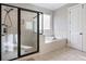 Modern bathroom with a glass-enclosed shower, soaking tub, tiled floor, and neutral color palette at 1459 Hedgewood Nw Ln, Kennesaw, GA 30152