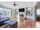 Sunlit living room featuring hardwood floors, custom built-ins, stone fireplace, and large windows with backyard views at 1459 Hedgewood Nw Ln, Kennesaw, GA 30152