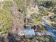 Aerial view of a wooded property featuring a house with a metal roof and a front porch near a street at 17 Cross Creek Pkwy, Dallas, GA 30157