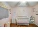 Cozy Bedroom with white crib, dresser, and soft pink walls under a ceiling fan at 17 Cross Creek Pkwy, Dallas, GA 30157