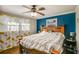 Blue accent wall behind king bed with wood floors and ceiling fan, plenty of natural light at 17 Cross Creek Pkwy, Dallas, GA 30157