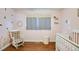 Adorable Bedroom with hardwood floors, soft pink walls, and a white rocking chair at 17 Cross Creek Pkwy, Dallas, GA 30157