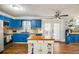 Bright kitchen with blue cabinets, modern appliances, a center island, and wood laminate flooring at 17 Cross Creek Pkwy, Dallas, GA 30157