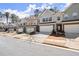 View of multiple townhomes with well-kept lawns along a tree-lined street at 2628 Wild Laurel Ct, Norcross, GA 30071