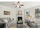 Cozy living room featuring a fireplace, large windows, a gray couch and patterned arm chairs at 2628 Wild Laurel Ct, Norcross, GA 30071