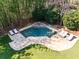 An aerial view of a luxurious pool area with stone decking and stylish lounge chairs, framed by bamboo at 4399 Jett Nw Pl, Atlanta, GA 30327