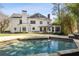 Relaxing backyard pool featuring a stone border, an outdoor patio, mature trees, and an exterior view of the home at 4399 Jett Nw Pl, Atlanta, GA 30327