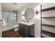 Modern bathroom featuring a glass shower, stylish vanity, and wooden shelving at 4399 Jett Nw Pl, Atlanta, GA 30327