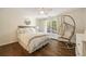 Cozy bedroom featuring a stylish hanging chair, hardwood floors, and a large window at 4399 Jett Nw Pl, Atlanta, GA 30327