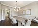 Bright dining room with chandelier, wood floors, large windows, art and white trim, with view to kitchen at 4399 Jett Nw Pl, Atlanta, GA 30327