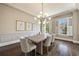 Elegant dining room with modern chandelier, hardwood floors, chair rail, and large windows with plantation shutters at 4399 Jett Nw Pl, Atlanta, GA 30327