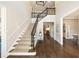 Spacious foyer with hardwood floors, a carpeted staircase with iron railings, and views to living and dining areas at 4399 Jett Nw Pl, Atlanta, GA 30327