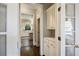 Hallway featuring hardwood floors and white trim, with a view into the sunlit kitchen with an island at 4399 Jett Nw Pl, Atlanta, GA 30327