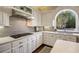 A gourmet kitchen with white cabinetry, a gas cooktop, and a large arch window that provides natural light at 4399 Jett Nw Pl, Atlanta, GA 30327