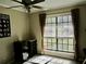 Cozy bedroom featuring large window that lets in natural light and a ceiling fan at 901 Guys Sw Ct, Lilburn, GA 30047