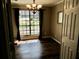 Bright dining room featuring hardwood floors, a modern chandelier, and a large window with natural light at 901 Guys Sw Ct, Lilburn, GA 30047