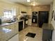 Well-lit kitchen with tile flooring, granite countertops, and black appliances at 901 Guys Sw Ct, Lilburn, GA 30047