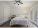 Cozy bedroom with wood floors, a ceiling fan, and light walls; door to outside at 115 Ashford Cir, Dunwoody, GA 30338