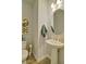 Charming half-bath with a pedestal sink, decorative mirror, and unique wall art at 39 Clubhouse Way, Acworth, GA 30101