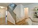 Elegant staircase with black metal railings, carpeted steps, and wood flooring in a bright, open space at 39 Clubhouse Way, Acworth, GA 30101